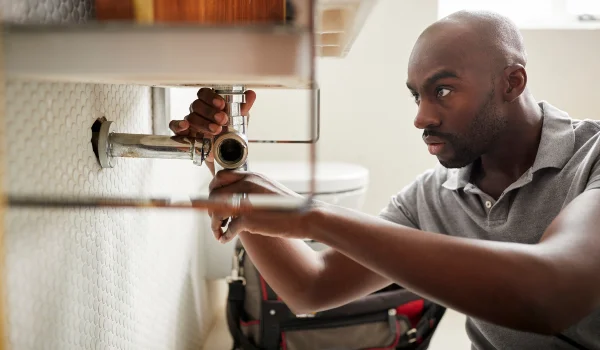 a male plumber fixing a bathroom faucet from quality plumbing leander in Leander, TX - Leander, TX